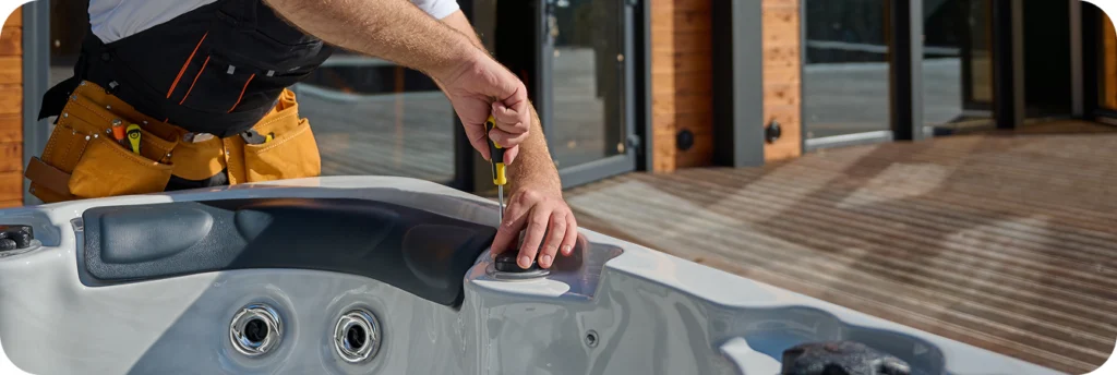 Technician performing hot tub repair in a backyard in Barrie.